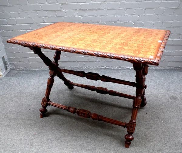 An early Victorian centre table, the interlocked geometric parquetry top on a lappet carved oak 'X' frame base, 112cm wide x 78cm high x 70cm deep.