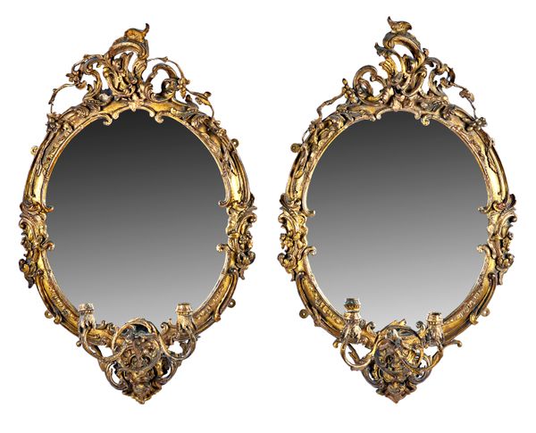 A pair of Victorian gilt framed girandole wall mirrors, each with 'C' scroll crest over foliate shaped oval frames and twin candle sconce, 65cm wide x