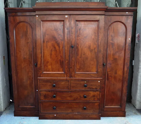 A Victorian mahogany breakfront compactum wardrobe, the central linen press with pair of doors over two short and two long graduated drawers, flanked