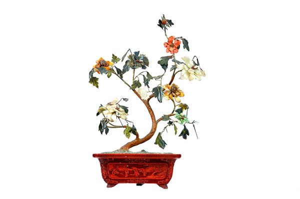 A Chinese hardstone tree in a cinnabar lacquer jardiniere, 19th, the tree applied with coloured hardstone leaves, set in a rectangular lacquer planter