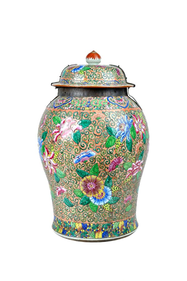 A Large Chinese famille-rose baluster jar and cover, 19th century, brightly painted with flowers and tendrils against a salmon- pink ground, with a me