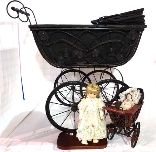 A 20th century iron framed child's pram, a similar miniature pram and a small doll.  E4