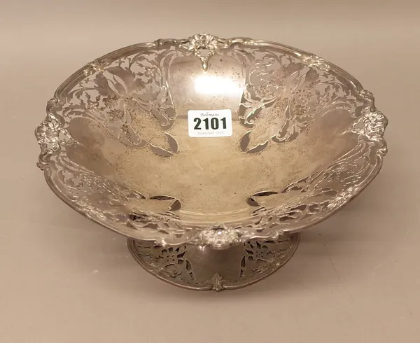 A silver pedestal fruit basket, with pierced decoration within a floral and scroll cast rim, raised on a similarly decorated shaped circular foot, dia
