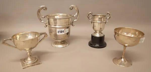 Silver, comprising; a twin handled trophy cup raised on a black composition stand, Birmingham 1932 and three further trophy cups, all inscribed, combi