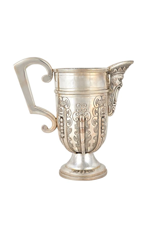 An Italian wine jug, with cast decoration to the mask spout and to the body, in the 18th century taste, raised on a circular foot, with a fitted case,