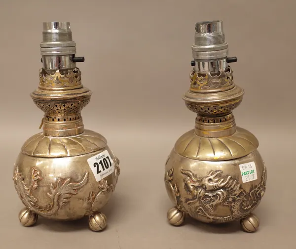 A pair of plated Asian table lamps, each base of spherical form, decorated with a dragon and raised on three melon form feet and further plated wares,