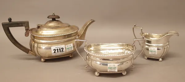 A silver composite three piece tea set, comprising; a teapot, a twin handled sugar bowl and a milk jug, each piece decorated with a gadrooned rim and