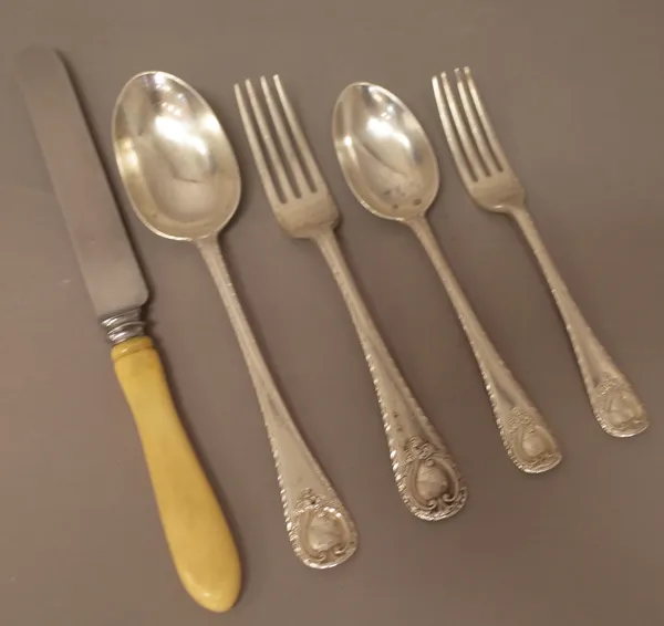 A silver part canteen of table flatware, in a single struck, feather edged pattern, having Rococo cartouche terminals to the handles, comprising; seve