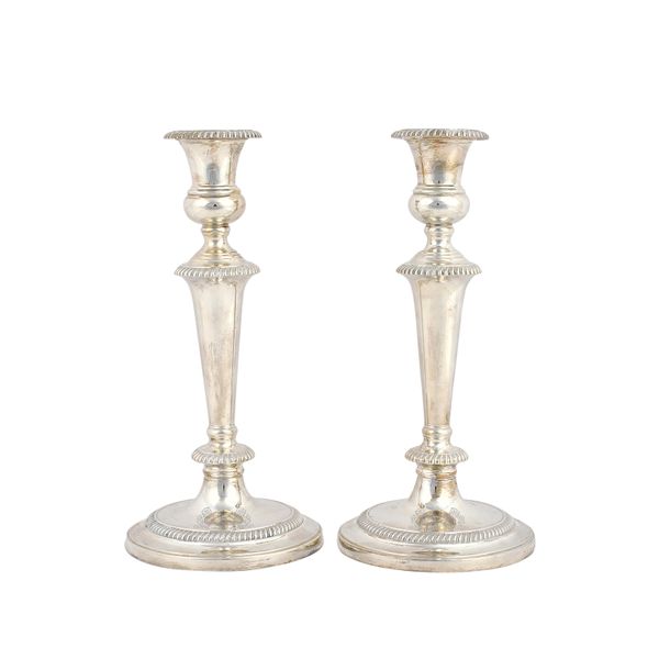 A pair of silver table candlesticks, each with a tapered stem, gadrooned rims, detachable sconce and raised on a circular foot, (loaded), height 26.5c