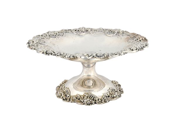 An American Sterling silver pedestal fruit or cake basket, of shaped circular form, the rim with a bold border, pierced with floral, foliate and scrol