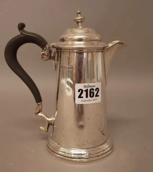 A silver hot water jug, of tapering cylindrical form, in the 18th century taste, with a black composition handle, the hallmark rubbed, gross weight 27