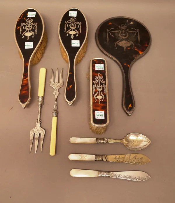 A lady's silver and tortoiseshell mounted four piece part dressing set, comprising; a hand mirror, two hairbrushes and a clothes brush, mostly London