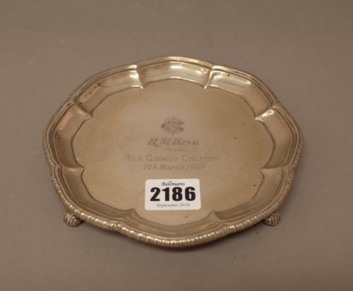 A shaped circular waiter, presentation inscribed to the centre R.M. King, from The Guindy Golfers 7th March 1964, raised on four scrolling feet, detai