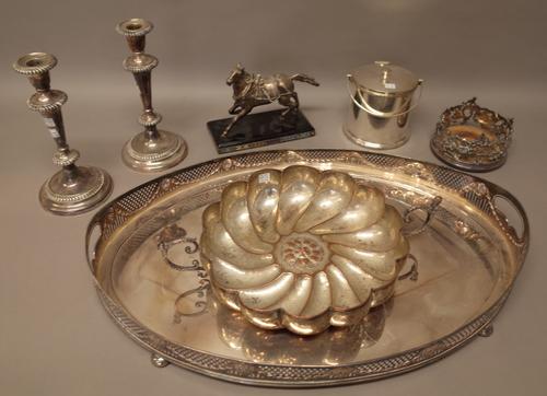 Plated wares, comprising; an oval twin handled gallery tray, raised on bun feet, a pair of table candlesticks, a hinge lidded cylindrical biscuit box,