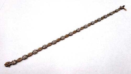 A 9ct gold and diamond set bracelet, the links in a quatrefoil shaped link design, mounted with circular cut diamonds, on a snap clasp, with a foldove