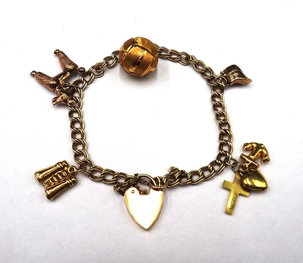 A gold twin curb link charm bracelet, with a 9ct gold heart shaped padlock clasp, fitted with five pendants and charms, including; a football, a poodl