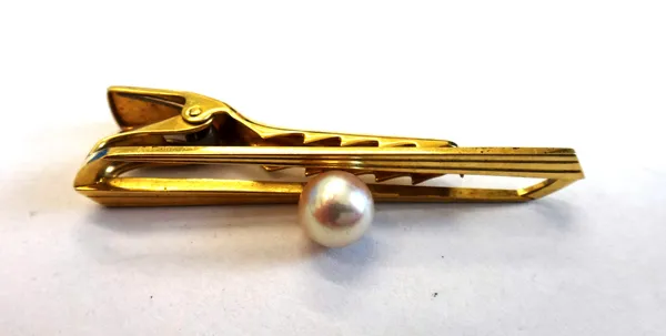 A gentleman's gold tie clip, mounted with a central cultured pearl, detailed K 14, by Mikimoto, gross weight 6.5 gms.