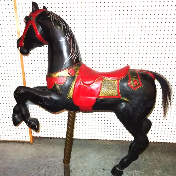An early 20th century black painted composite carousel horse on twisted brass column stand,  100cm wide x 108cm high.  D7