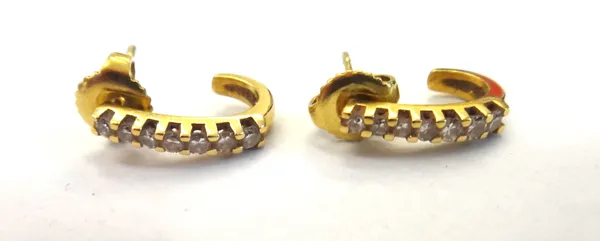 A pair of gold and diamond set earrings, each in a curved design, mounted with a row of seven circular cut diamonds, detailed 18 KT 750, the backs wit