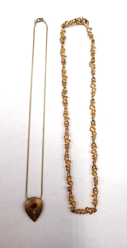 A 9ct gold, carbuncle garnet and diamond set pendant necklace, having a matt finish, with a 9ct gold Brazil link neckchain, on a sprung hook shaped cl