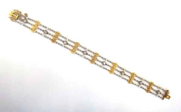 A gold two colour, diamond and seed pearl bracelet, circa 1910, in a three row design, the central row spaced with eight cushion shaped diamonds and w