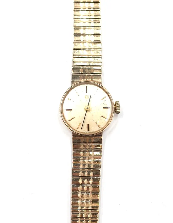 An Omega 9ct gold lady's bracelet wrist watch, the signed dial with baton shaped numerals, on a tapering gold bracelet, with a fold over clasp, gross