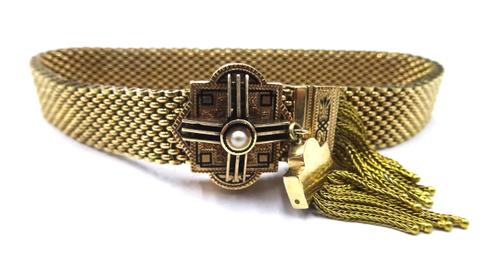 A woven mesh link bracelet, fitted with a black enamelled and half pearl set slide and with two rows of pendant tassels, having black enamelled surmou