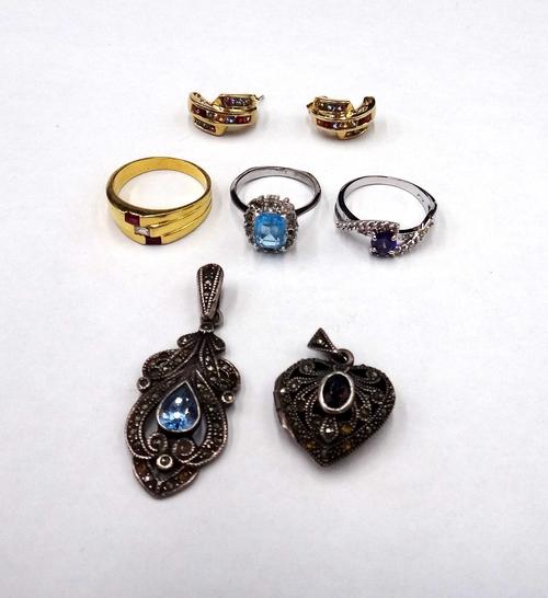 A gold, diamond and red gem set ring, mounted with the emerald cut diamond to the centre, detailed 750, ring size P and a half, gross weight 5.4 gms,