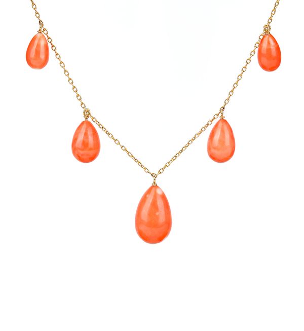 A gold and coral necklace, the front mounted with five graduated drop shaped pendant coral beads, on an oval link neckchain, with a boltring clasp. Il