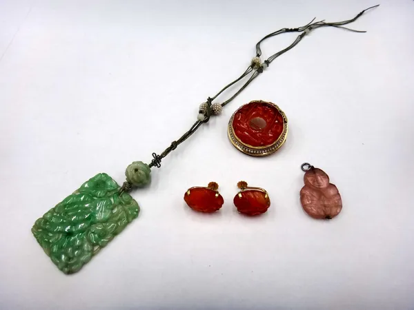 A Chinese carved jade panel shaped pendant necklace, decorated with flowers and fruit, the cord suspension decorated with seed pearl beads, a gold mou