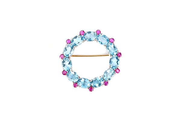 A ruby and aquamarine brooch, in an openwork circular design, mounted with oval cut aquamarines and with smaller circular cut rubies mounted at interv
