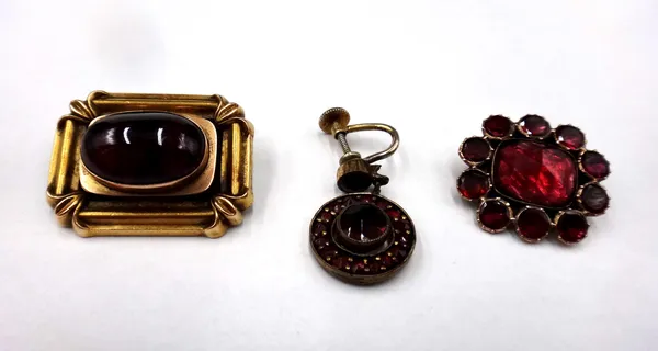 A faceted and flat cut garnet set brooch, circa 1830, a Victorian shaped rectangular brooch, mounted with an oval carbuncle garnet, detailed to the ba