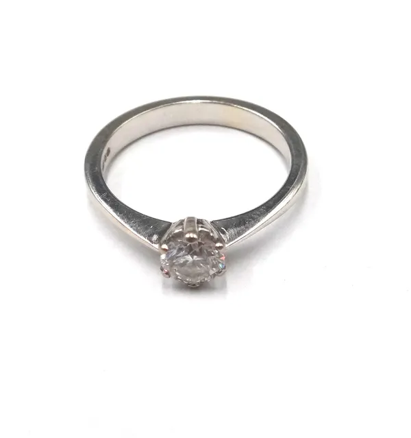 An 18ct white gold and diamond single stone ring, claw set with a circular cut diamond, ring size L and a half.