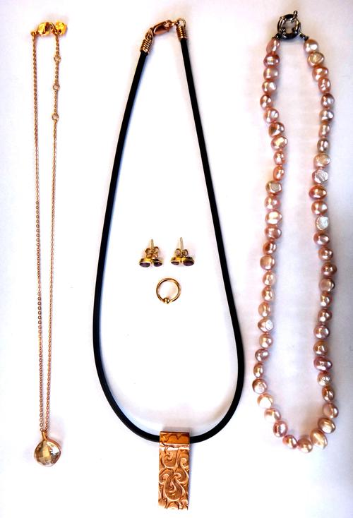 A Swarovski crystal solitaire pendant with a neckchain, a pair of garnet two stone earstuds, each mounted with two pear shaped garnets, the backs with