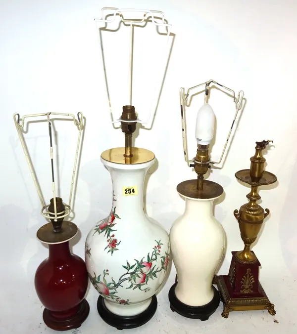 A 20th century Chinese baluster lamp decorated with fruit, a white glazed baluster lamp, a smaller red glazed lamp and a Regency style gilt metal lamp