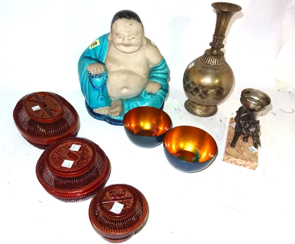 A group of Asian works of art, comprising; a biscuit and turquoise glazed seated Buddha; a silver metal elephant converted to a lamp; an Indian brass
