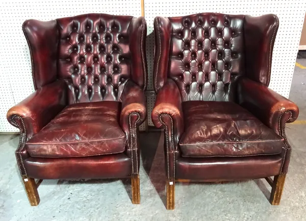 A pair of George III style mahogany framed wingback armchairs with red leatherette button back upholstery on square block supports, (2).  I4