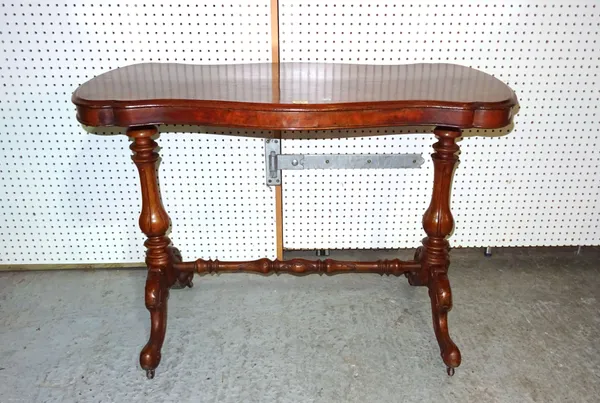 A Victorian walnut serpentine centre table on fluted bulbous supports, united by turned stretcher, 104cm wide x 74cm high.   I7