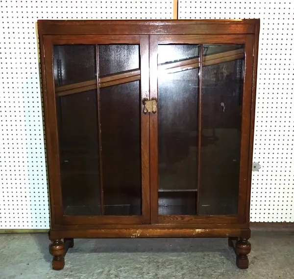 A 20th century oak two door bookcase on bulbous turned supports, 92cm wide x 116cm high, (a.f).  H5