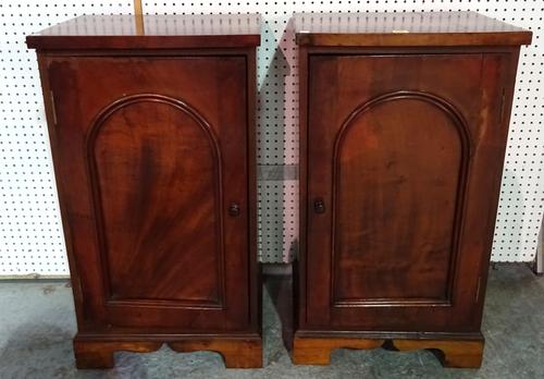 A pair of 20th century mahogany bedside cupboards with arch panel doors on bracket feet, 49cm wide x 89cm high, (2).  BAY 2