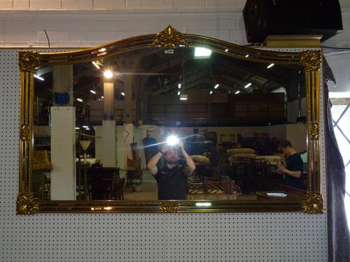 A 20th century gilt framed arch top mirror with scroll decoration, 183cm wide x 108cm high. A7