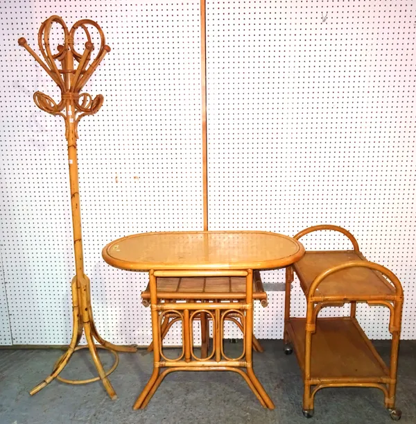 A 20th century bamboo suite comprising an oval centre table, 78cm wide x 75cm high, a two tier serving trolley 60cm wide x 70cm high and a coat/hat st