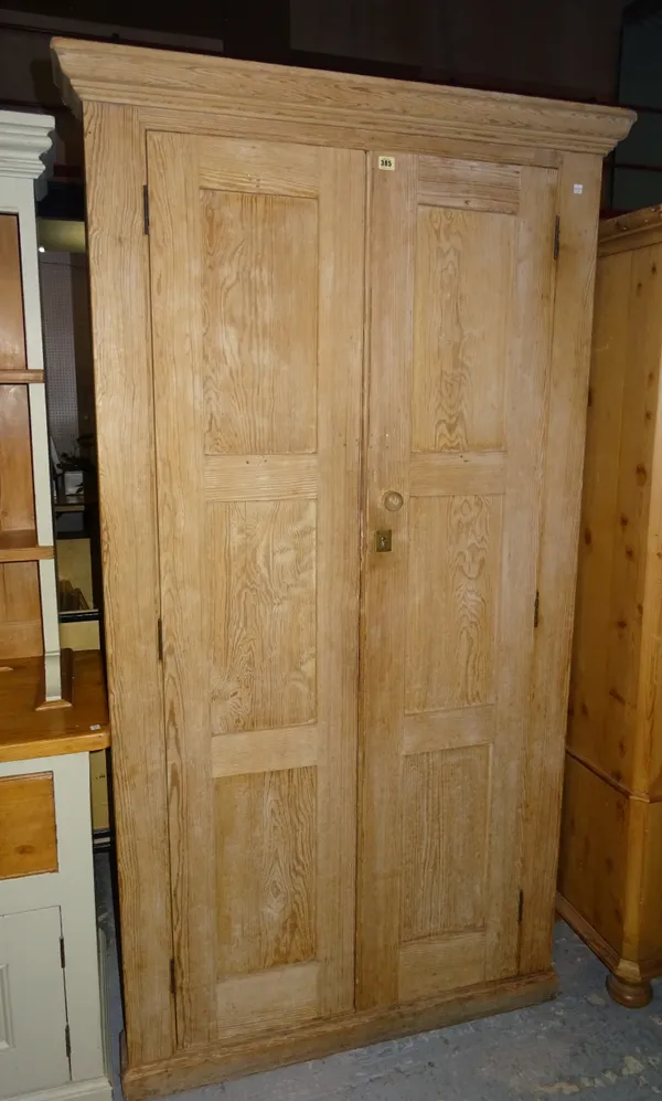 A 20th century pine double wardrobe with panel doors on plinth base, 108cm wide x 198cm high.  M8