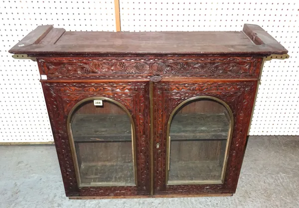 An early 20th century rosewood display cabinet with arch panelled glass doors and carved decoration, 94cm wide x 74cm high.  A8