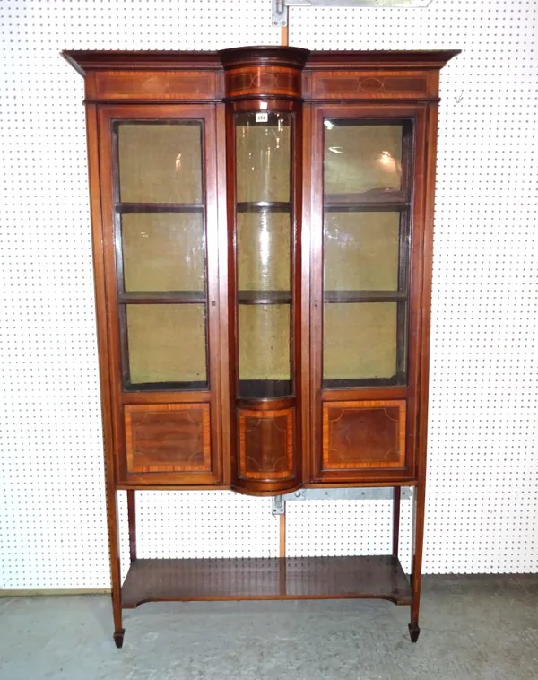 An Edwardian mahogany marquetry inlaid bowfront display cabinet on square tapering supports, 106cm wide x 186cm high, (a.f).   M8