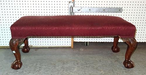 An early 20th century mahogany rectangular footstool on ball and claw feet, 92cm wide x 32cm high.   J4