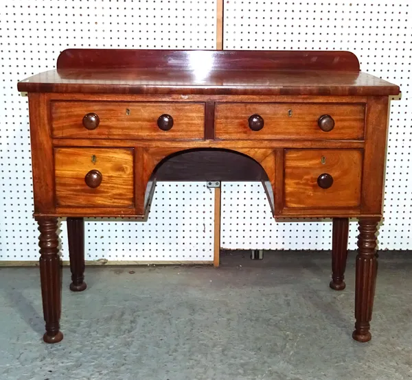 A late Regency mahogany kneehole desk on reeded tapering supports, 102cm wide x 84cm high x 53cm deep.  F9