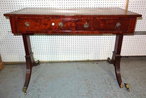 A Regency mahogany writing table with green leather inset top on reeded sabre supports, 104cm wide x 78cm high, (a.f).   J7