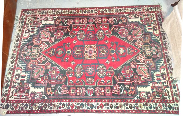 A Bakhtiari rug, the black field with a bold madder medallion, angular motifs and flowerheads, ivory spandrels, an ivory trailing flower border, 190cm
