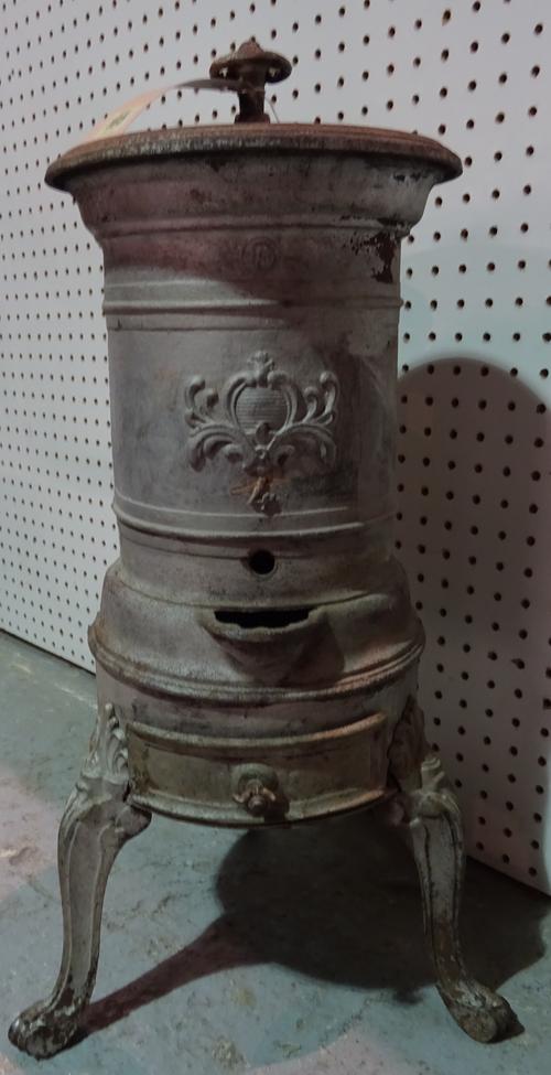 An early 20th century French cast iron stove on three cabriole supports, 25cm wide x 65cm high.
